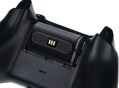 53d106e8-39be-4a49-a8a1-0a8cd372d31b Rechargeable battery pack installed in the back of a game controller showing contact gold pins and +/- indicators