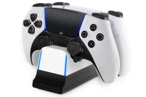 fbaf9c63-efe1-462a-a982-3614761bb044 (1) White PlayStation DualSense controller resting on a black charging dock with blue LED accents on the edges.