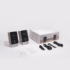 Two wooden bookshelf speakers with black fronts and silver bases, beside a white M60 box with cables and manuals nearby.
